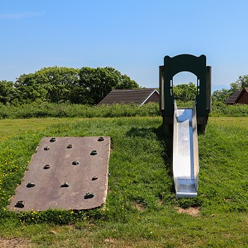 a slide and climbing wall at the park